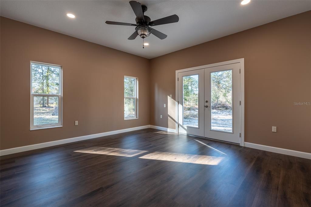 6425 Cartwrite Road Spring Hill, FL 34609 - Photo 45 of 74 a view of an empty room with wooden floor and a window