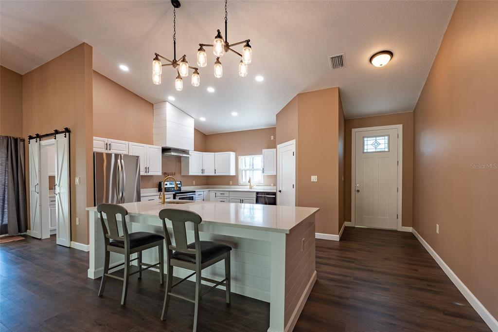 6425 Cartwrite Road Spring Hill, FL 34609 - Photo 7 of 74 a view of a dining room with furniture and wooden floor