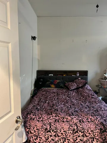 a large bed sitting in a bedroom next to a window
