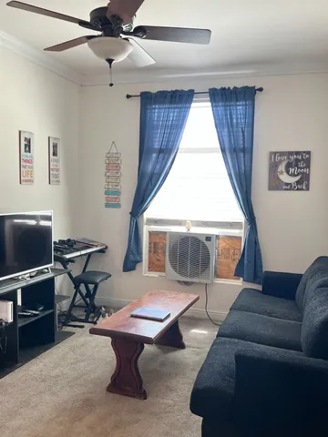 a living room with furniture a window and a flat screen tv
