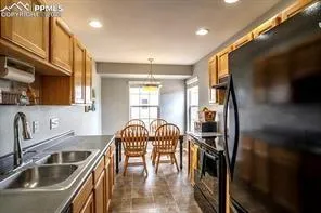 a kitchen with granite countertop a sink a stove and refrigerator