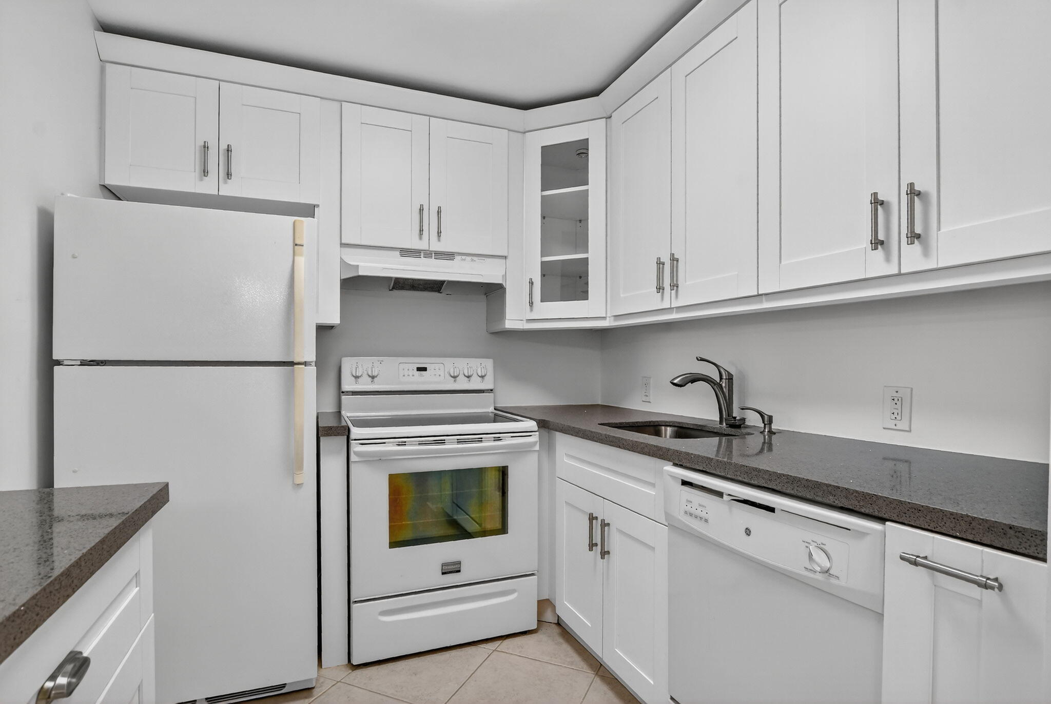 177 Fanshaw East, Unit 177 Boca Raton, FL 33434 - Photo 10 of 70 a kitchen with granite countertop white cabinets and refrigerator