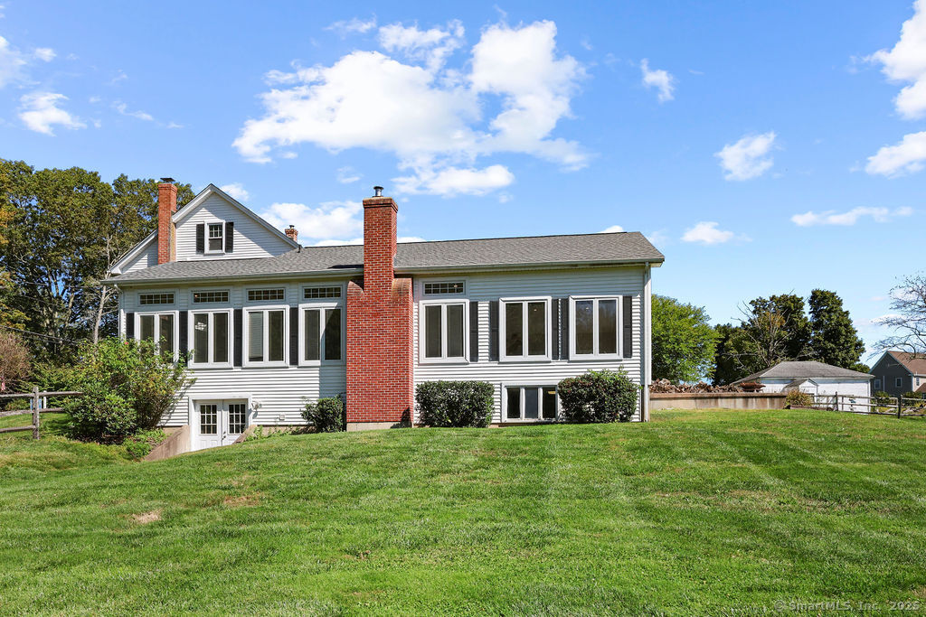 105 School Road Bolton, CT 06043 - Photo 30 of 39 a front view of a house with a yard table and chairs