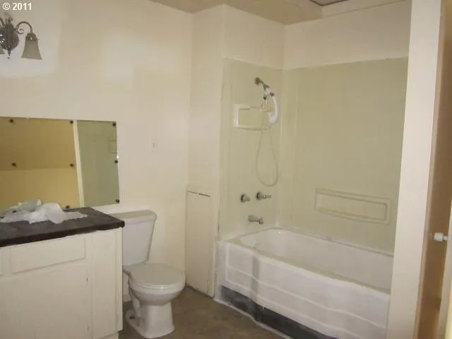 a bathroom with a granite countertop sink a toilet and bathtub