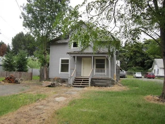 a view of a house with backyard and a tree