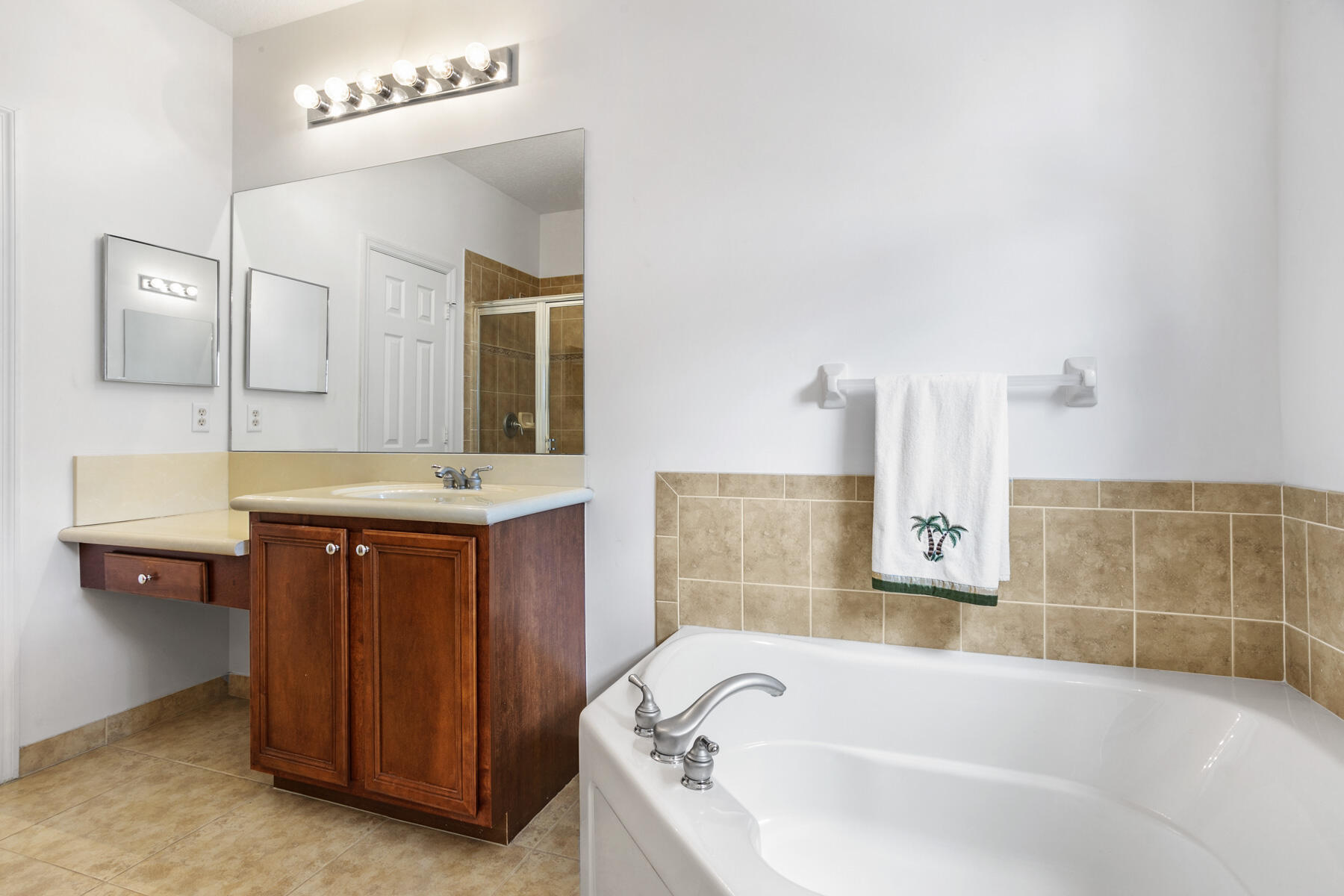 114 Locustberry Lane, Unit 101 Jupiter, FL 33458 - Photo 17 of 59 a bathroom with a tub sink and mirror