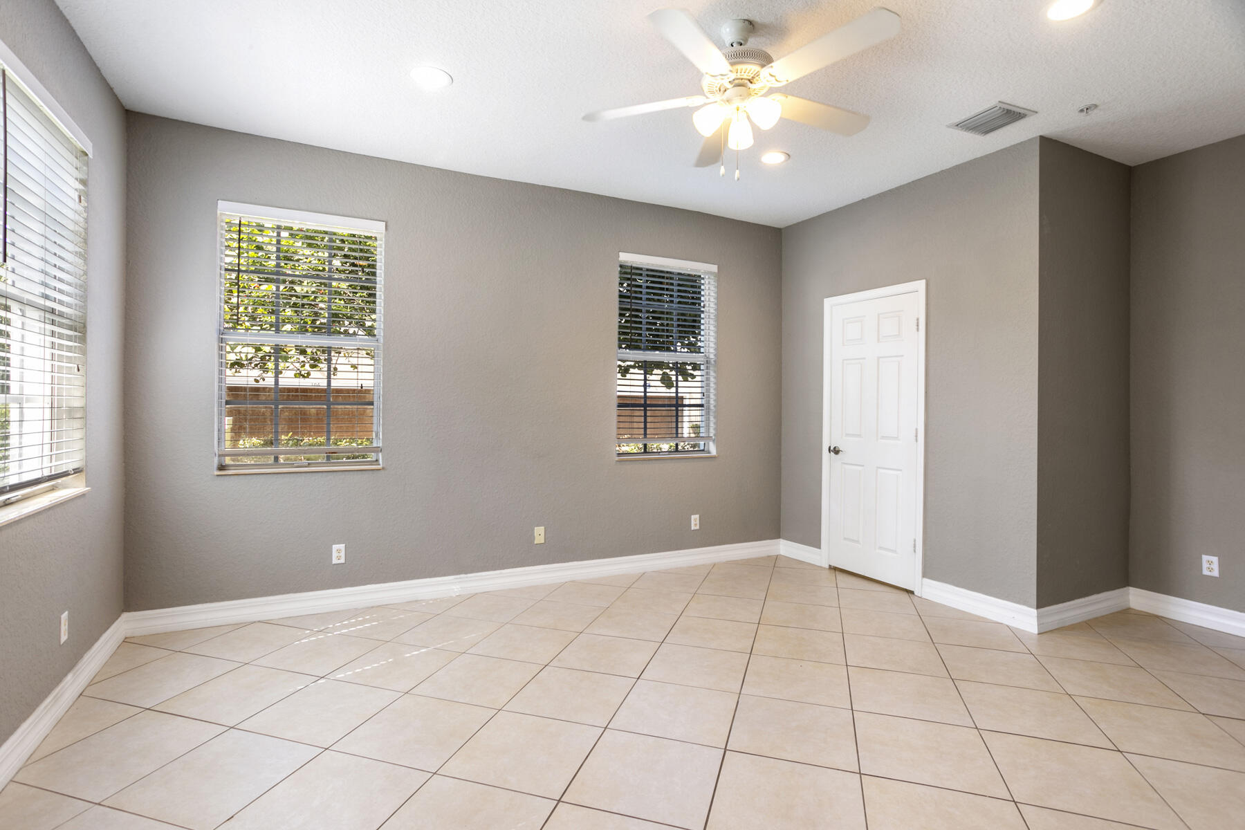 114 Locustberry Lane, Unit 101 Jupiter, FL 33458 - Photo 30 of 59 a view of an empty room with window and chandelier fan