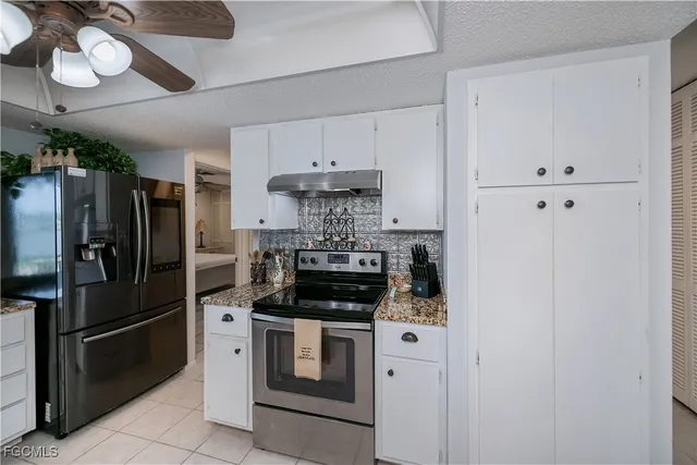 a kitchen with a granite countertop sink stove and cabinets