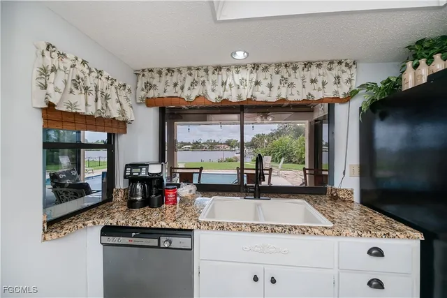 a kitchen with a sink a counter space appliances and cabinets