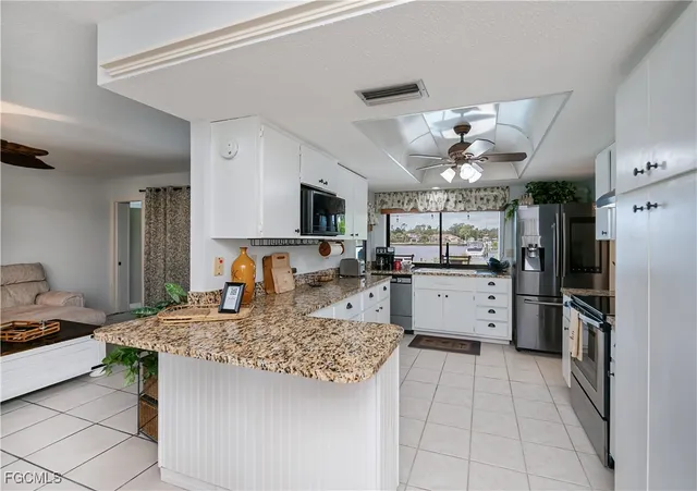 a kitchen with stainless steel appliances kitchen island granite countertop a sink cabinets and counter space
