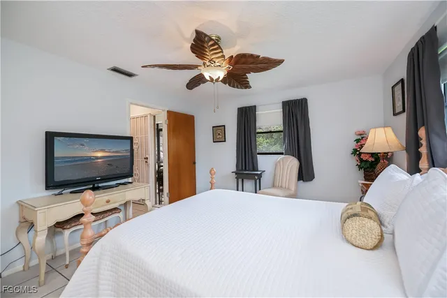 a bedroom with a bed a dresser and flat screen tv