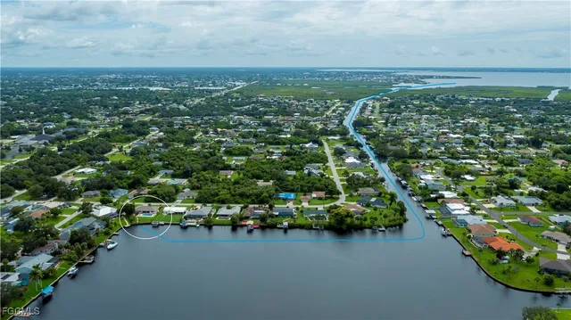 an aerial view of residential houses with outdoor space and trees