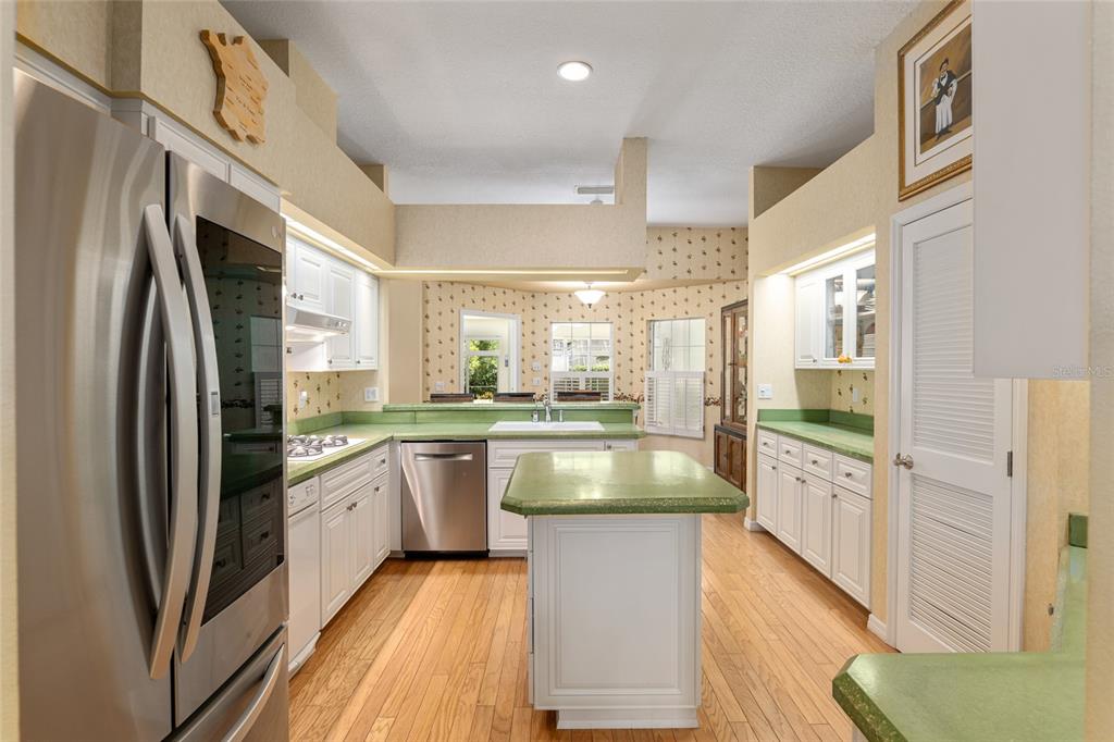 2215 Spring Hill Court Ocala, FL 34471 - Photo 15 of 62 a open kitchen with stainless steel appliances granite countertop a refrigerator a sink dishwasher a stove and white countertops with wooden floor