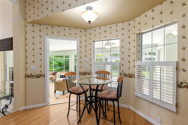 a dining room with furniture a chandelier and wooden floor