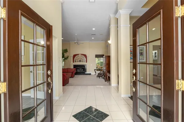a living room with furniture a fireplace and a floor to ceiling window