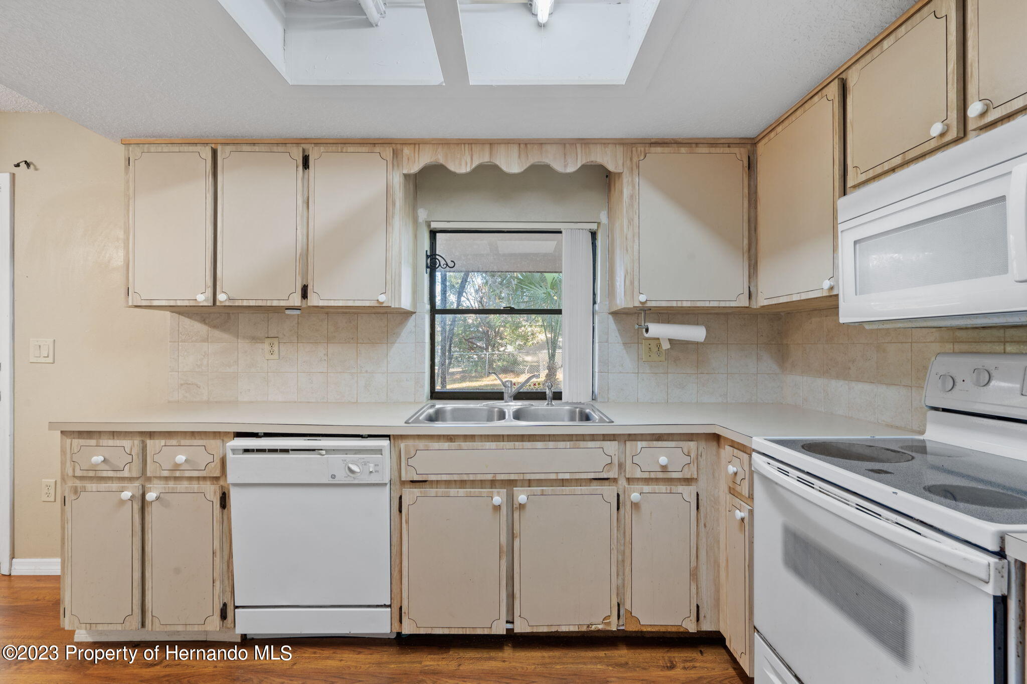 10479 Thornberry Drive Spring Hill, FL 34608 - Photo 18 of 44 a kitchen with granite countertop white cabinets white appliances and a sink