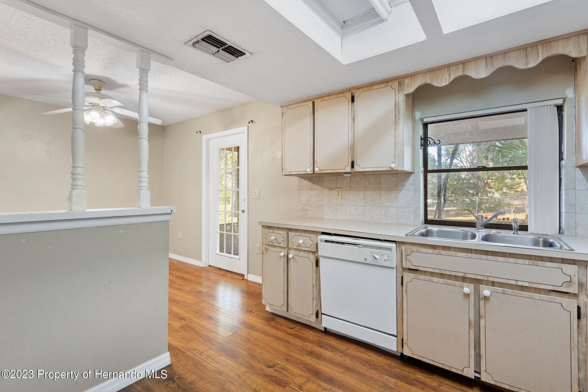 10479 Thornberry Drive Spring Hill, FL 34608 - Photo 19 of 44 a kitchen with stainless steel appliances white cabinets and wooden floors