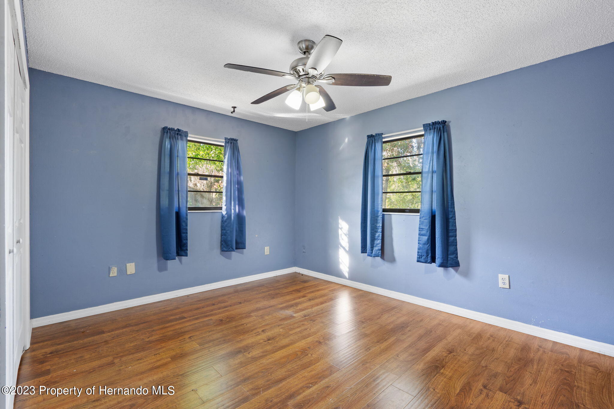 10479 Thornberry Drive Spring Hill, FL 34608 - Photo 24 of 44 a view of an empty room with window and wooden floor