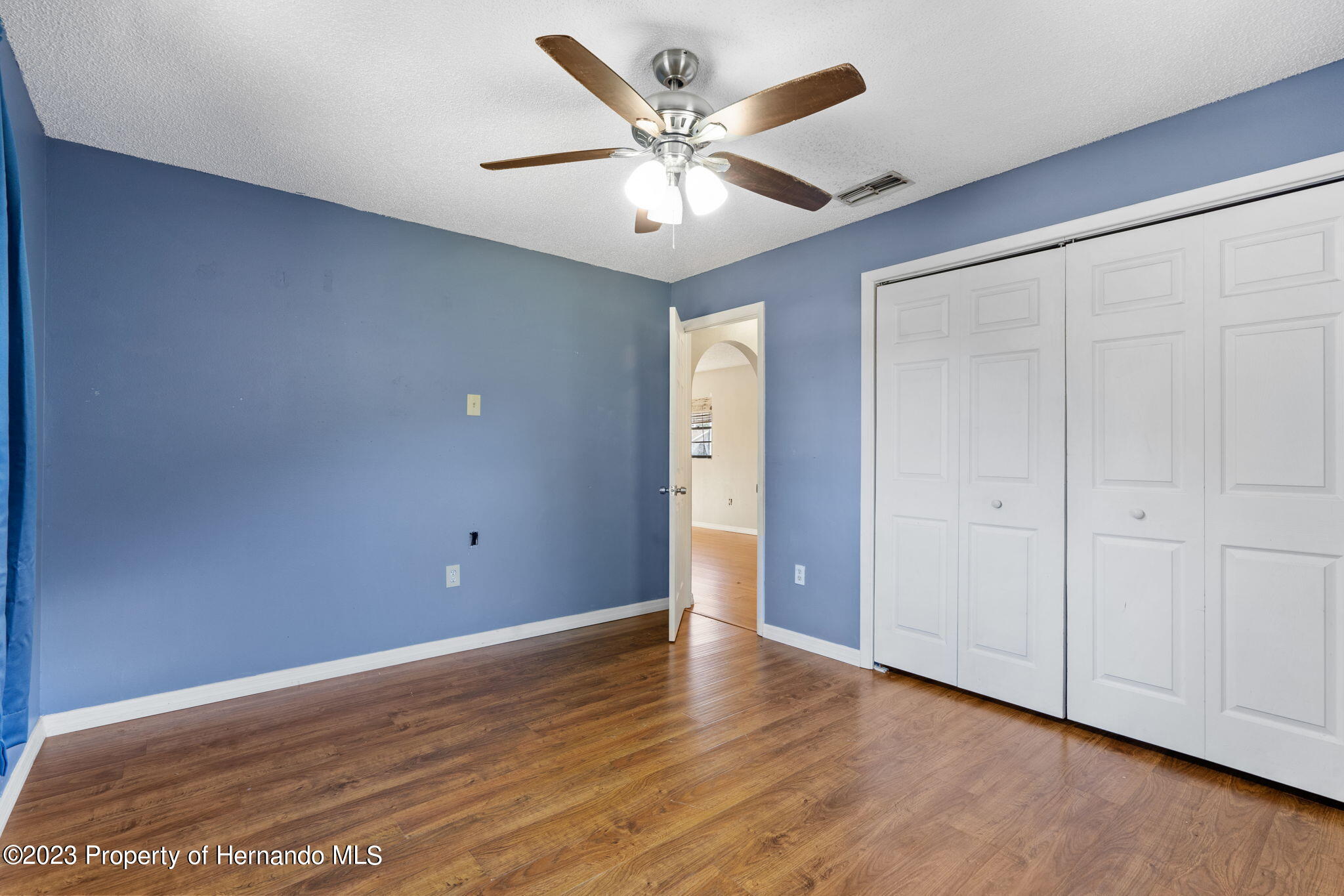 10479 Thornberry Drive Spring Hill, FL 34608 - Photo 25 of 44 a view of an empty room with wooden floor