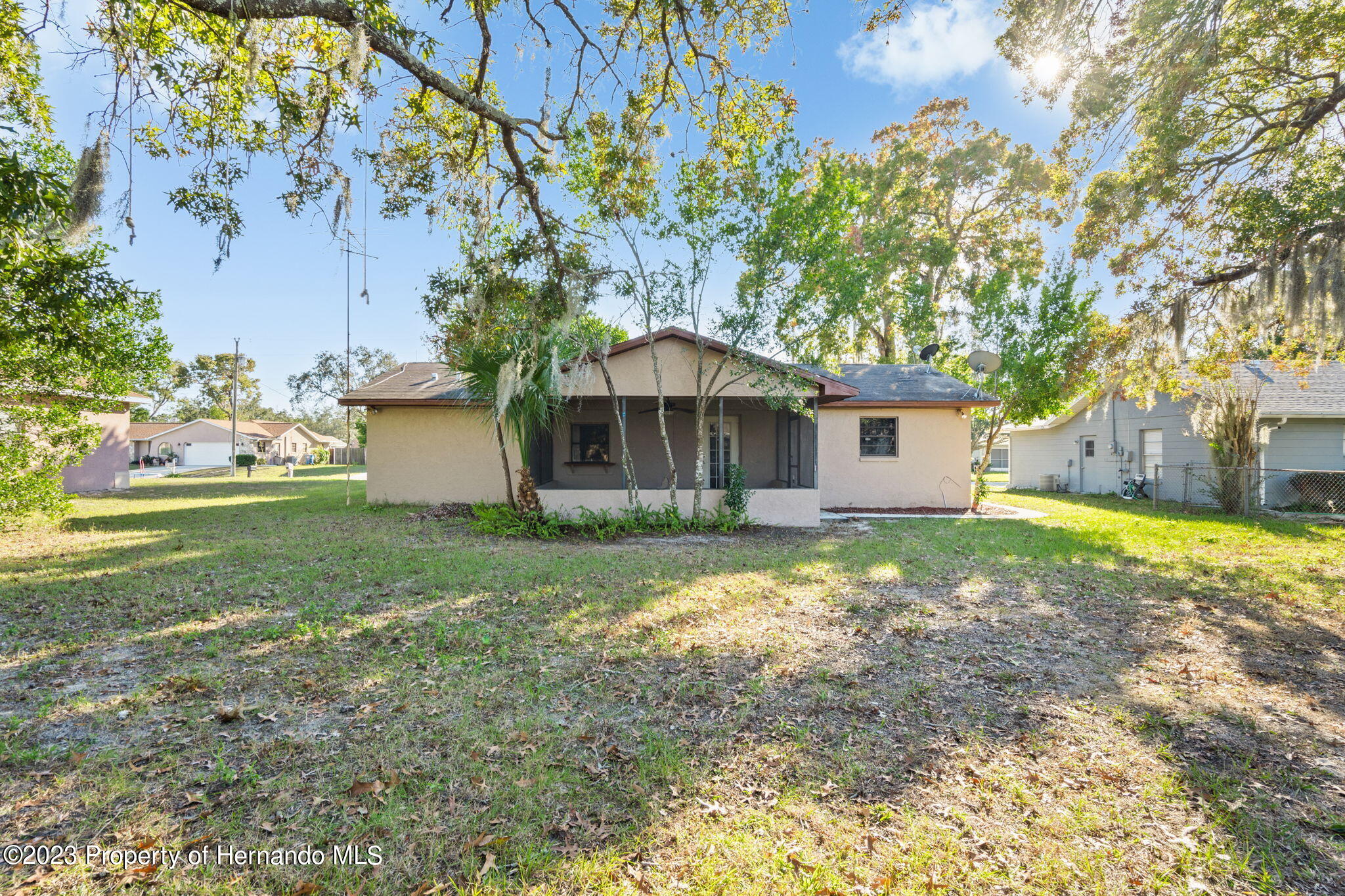 10479 Thornberry Drive Spring Hill, FL 34608 - Photo 30 of 44 a backyard of a house with table and chairs