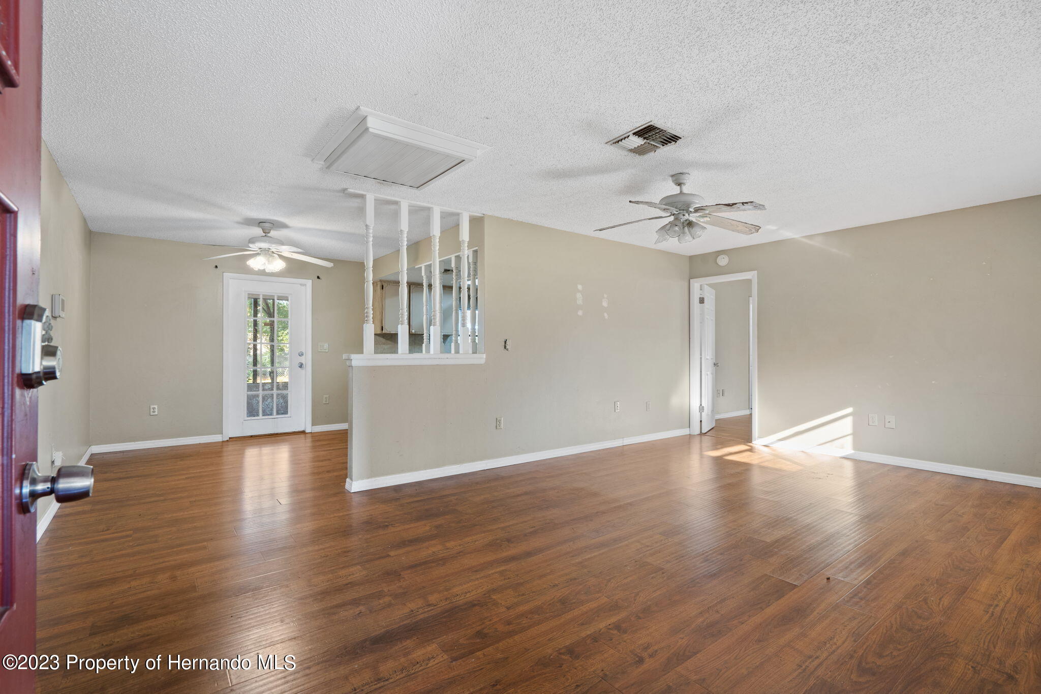 10479 Thornberry Drive Spring Hill, FL 34608 - Photo 9 of 44 a view of an empty room with wooden floor and a ceiling fan