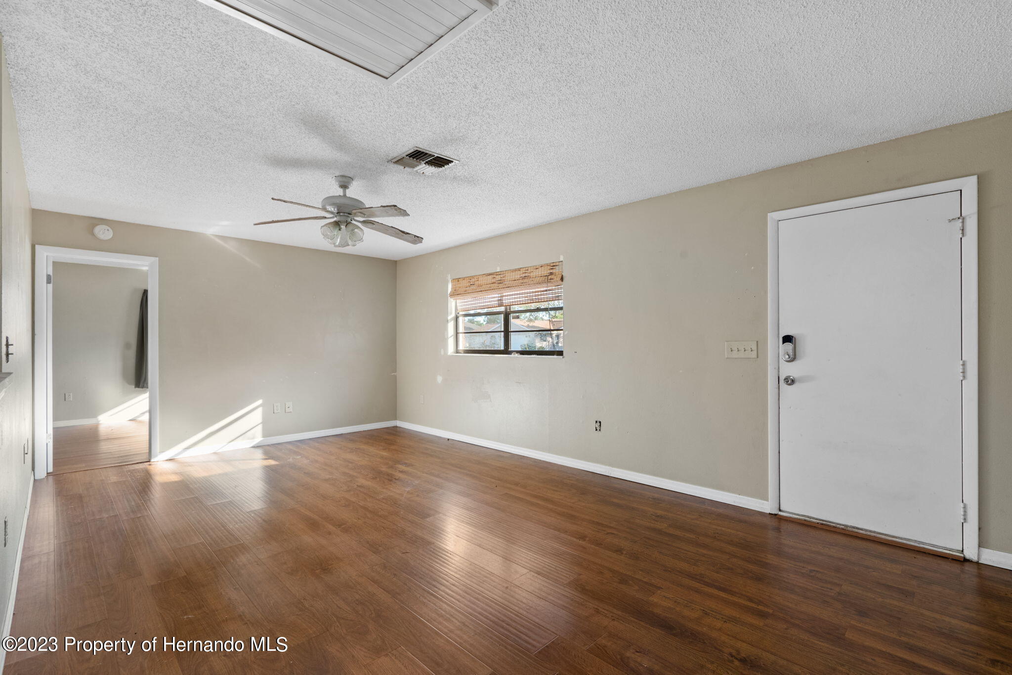 10479 Thornberry Drive Spring Hill, FL 34608 - Photo 10 of 44 a view of an empty room with wooden floor and a window