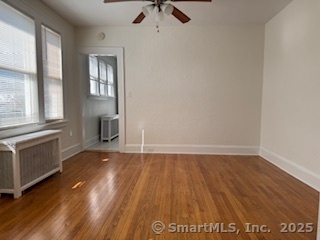 285 Clover Street, Unit 2 Stratford, CT 06614 - Photo 12 of 25 an empty room with windows and chandelier fan