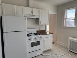 a kitchen with white cabinets and white appliances