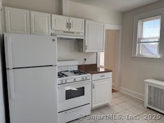 285 Clover Street, Unit 2 Stratford, CT 06614 - Photo 13 of 25 a kitchen with white cabinets and white appliances