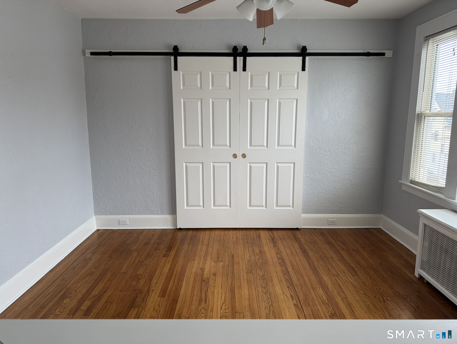 285 Clover Street, Unit 2 Stratford, CT 06614 - Photo 21 of 25 a view of an empty room with wooden floor and a window