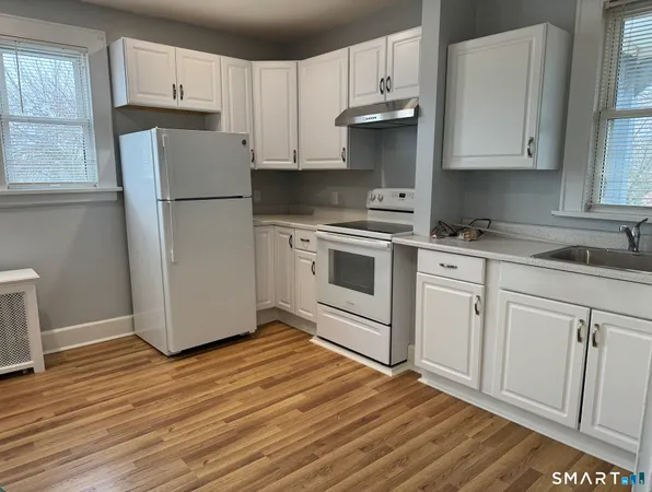 a kitchen with a refrigerator sink and cabinets