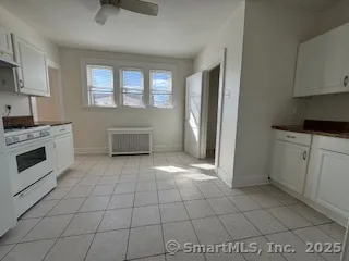 a kitchen with granite countertop a stove a sink and a refrigerator