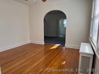 285 Clover Street, Unit 2 Stratford, CT 06614 - Photo 7 of 25 an empty room with wooden floor and windows
