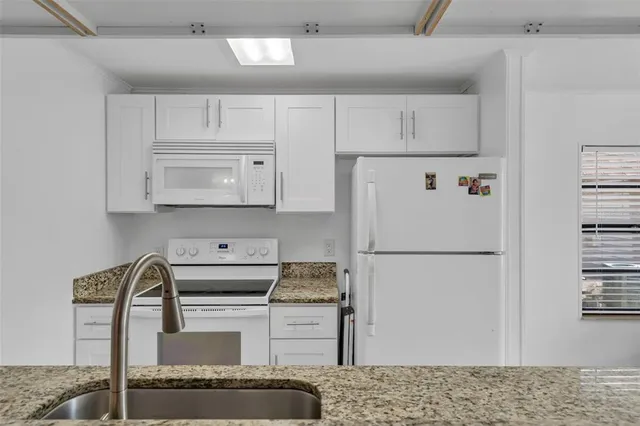 a white refrigerator freezer sitting inside of a kitchen