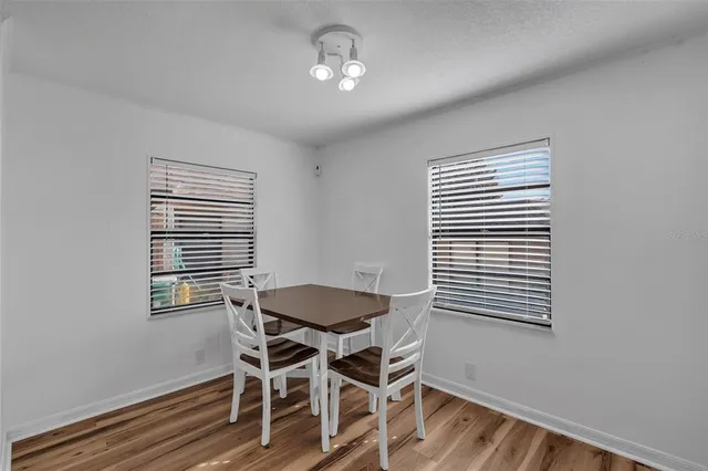 a dining room with wooden floor and chandelier