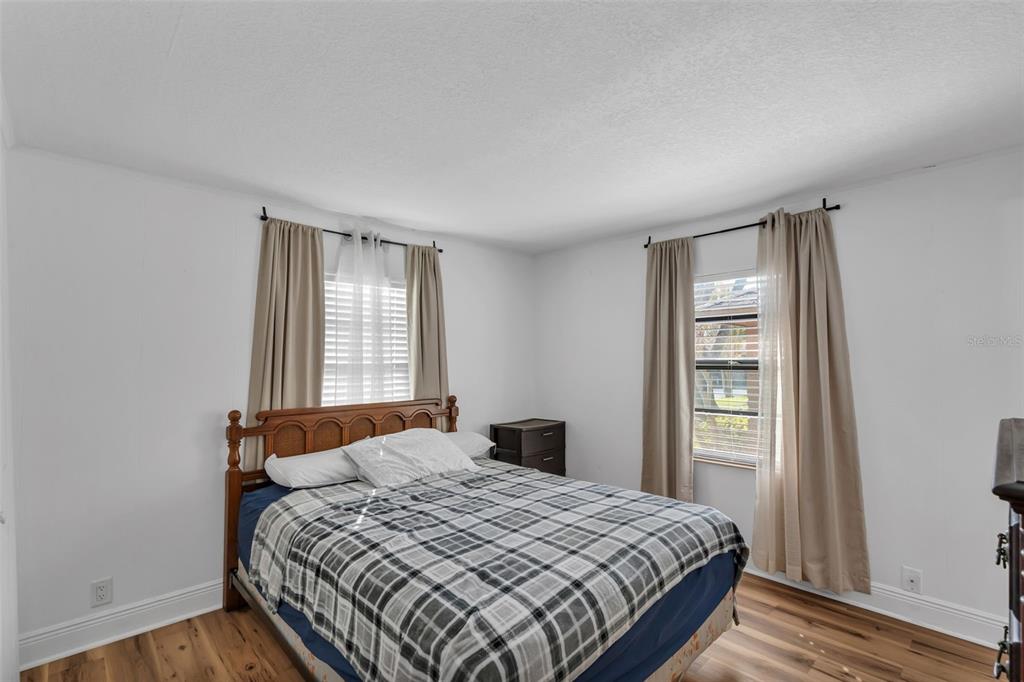 373 Eron Way, Unit 47 Winter Garden, FL 34787 - Photo 17 of 41 a bedroom with a bed and wooden floor