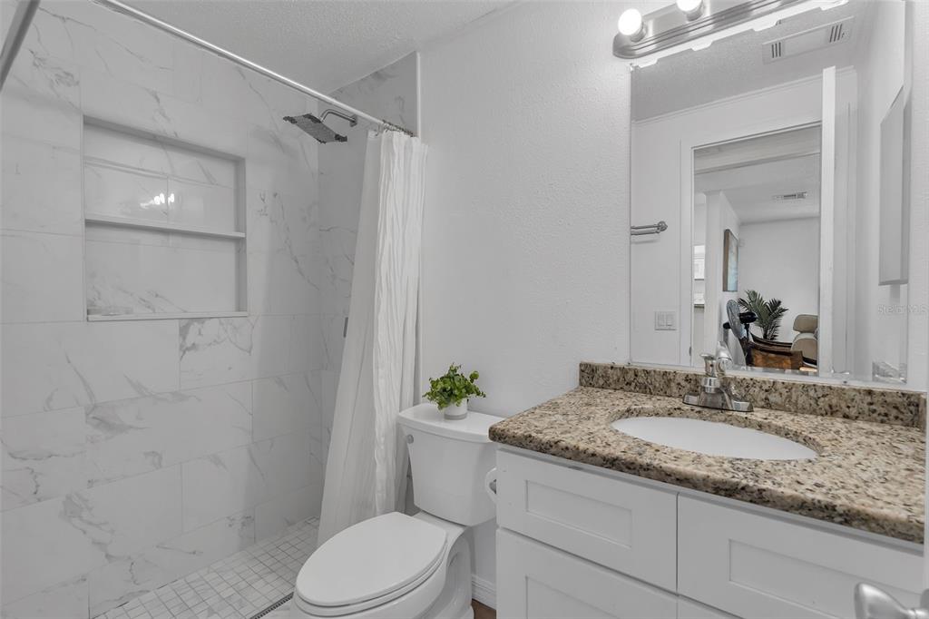 373 Eron Way, Unit 47 Winter Garden, FL 34787 - Photo 22 of 41 a bathroom with a granite countertop sink toilet and shower