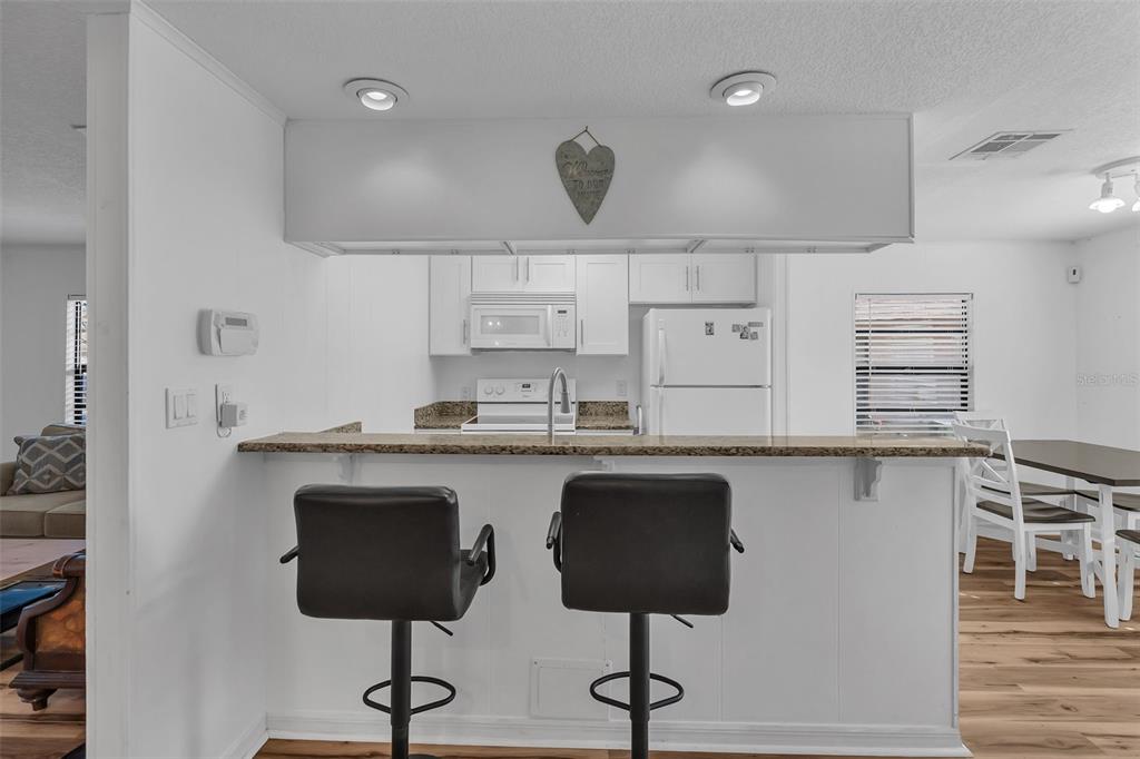 373 Eron Way, Unit 47 Winter Garden, FL 34787 - Photo 6 of 41 a kitchen with cabinets and chairs in it