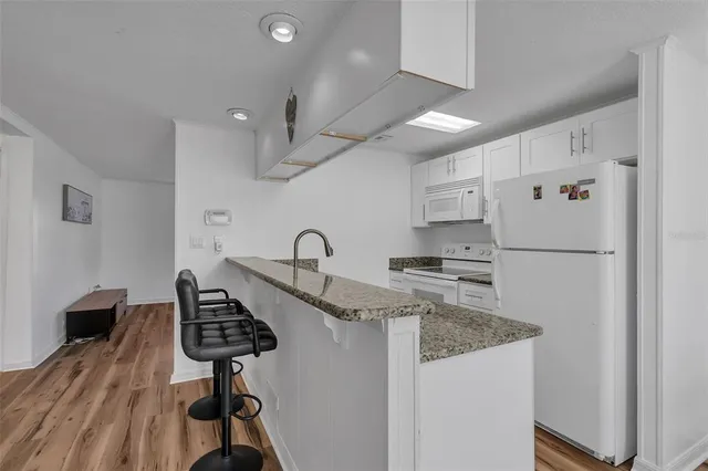 a kitchen with stainless steel appliances granite countertop a sink a stove and refrigerator