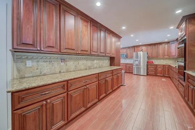 a kitchen with stainless steel appliances a refrigerator sink and cabinets