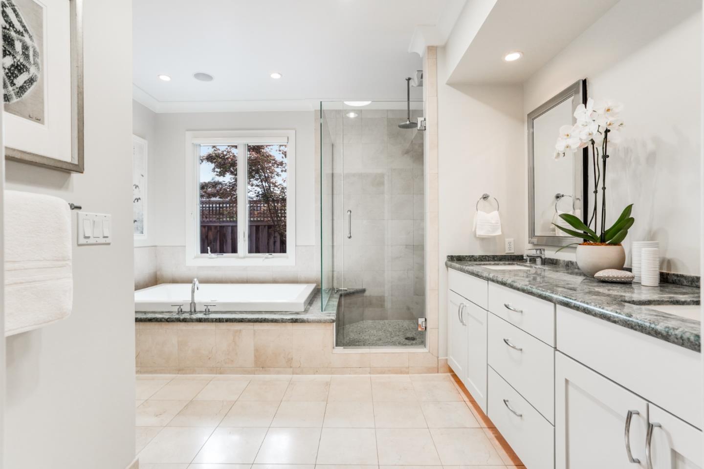 196 Merritt Road Los Altos, CA 94022 - Photo 19 of 46 a spacious bathroom with a granite countertop sink a mirror a shower and a bathtub