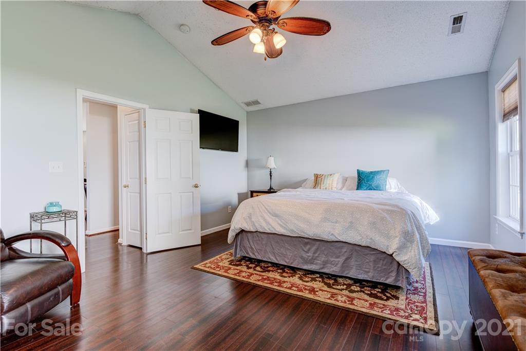 461 Planters Creek Road Fletcher, NC 28732 - Photo 11 of 26 a bedroom with a bed and a chandelier