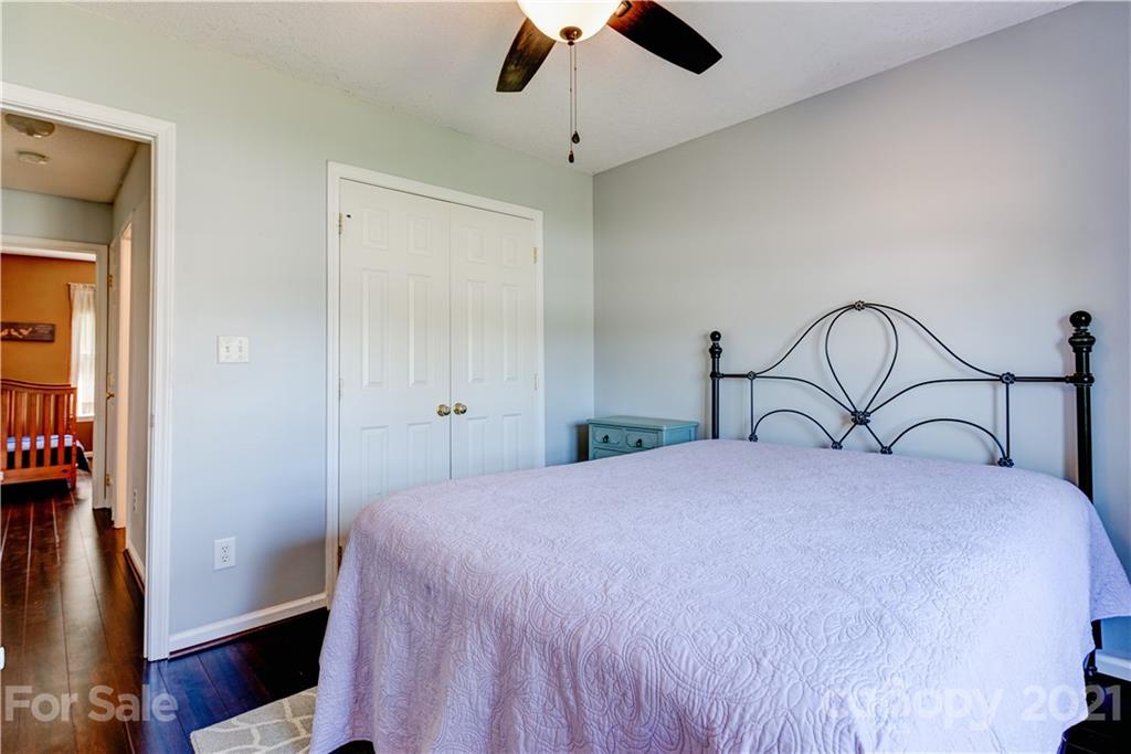 461 Planters Creek Road Fletcher, NC 28732 - Photo 18 of 26 a bedroom with a bed and a chandelier