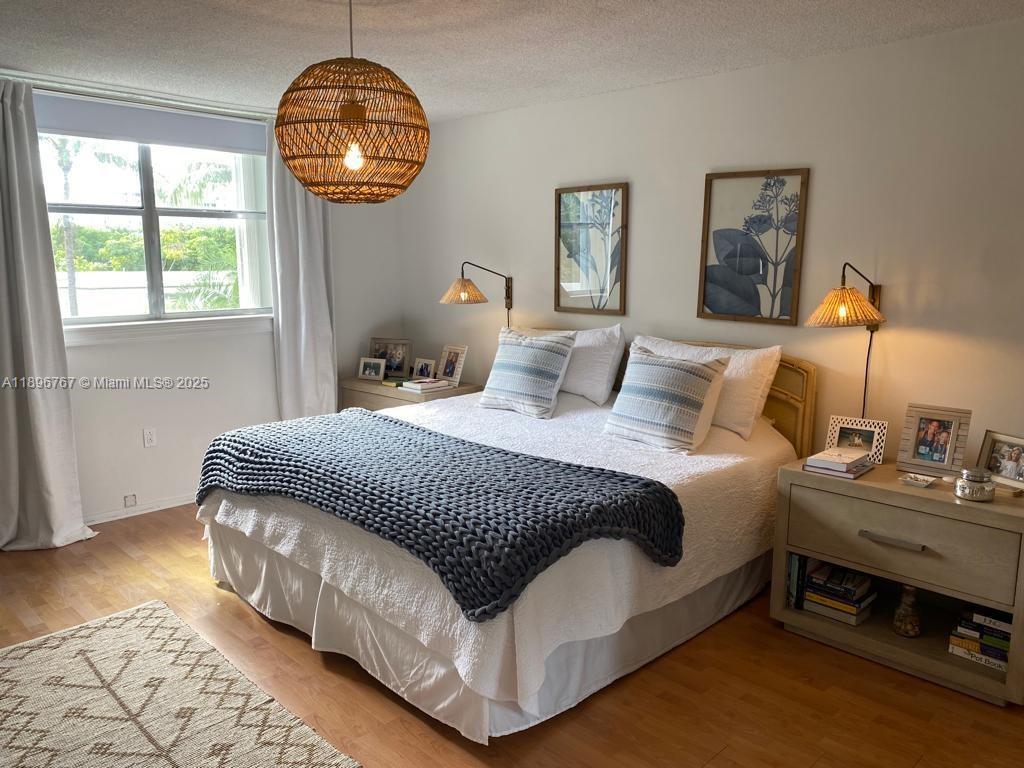 210 Seaview Drive, Unit 312 Key Biscayne, FL 33149 - Photo 23 of 26 a bedroom with a bed and a chandelier