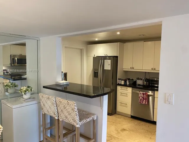 a kitchen with granite countertop a refrigerator and a stove top oven