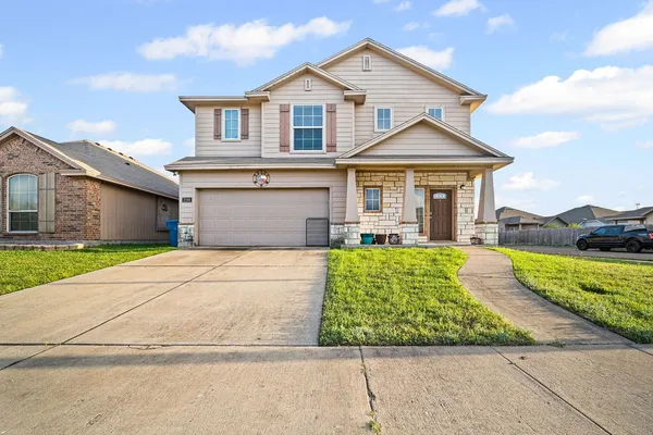 a front view of a house with a yard and garage