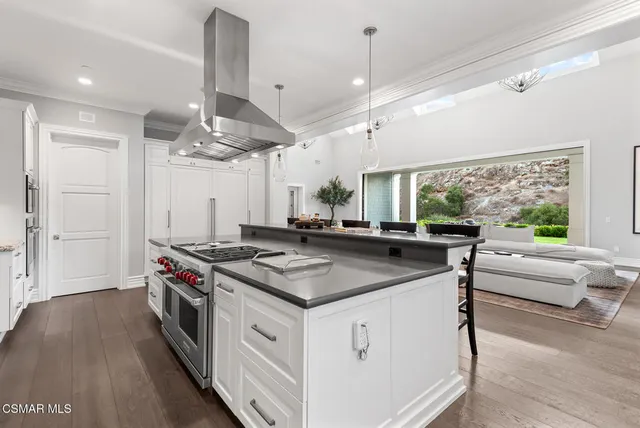 a kitchen with stainless steel appliances a stove and a large window