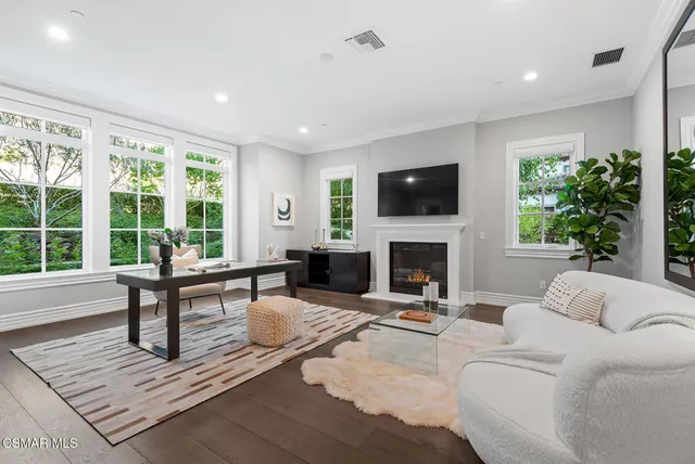 a living room with furniture a fireplace a flat screen tv and a large window