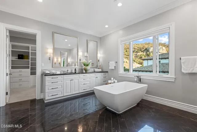 a spacious bathroom with a double vanity sink a mirror and a bathtub
