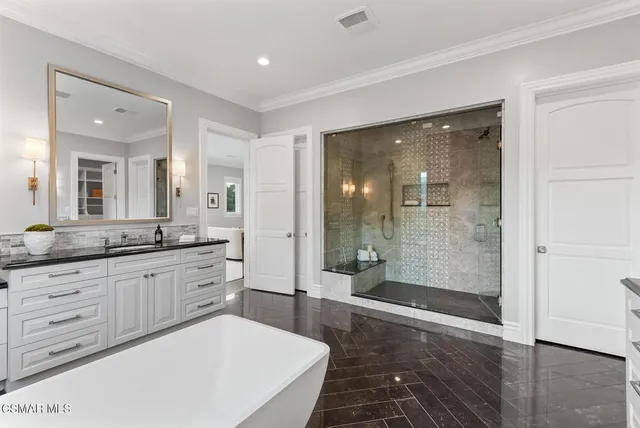 a spacious bathroom with a granite countertop sink a mirror and a shower